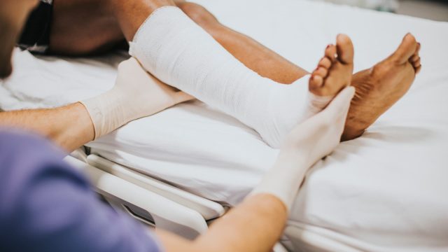 doctor-helping-patient-with-fractured-leg (1)
